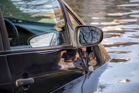 Car is surrounded by water