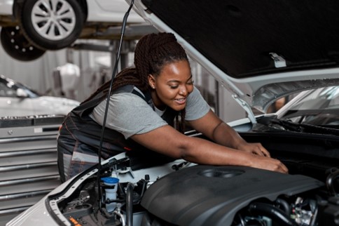 A mechanic works on a damaged car