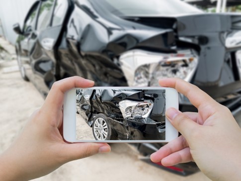 Person takes photo of damaged car