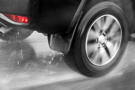 Car wheel driving through the rain